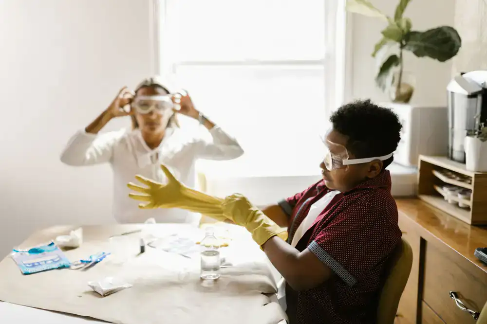 Children wearing safety goggles smiling during a colorful science experiment