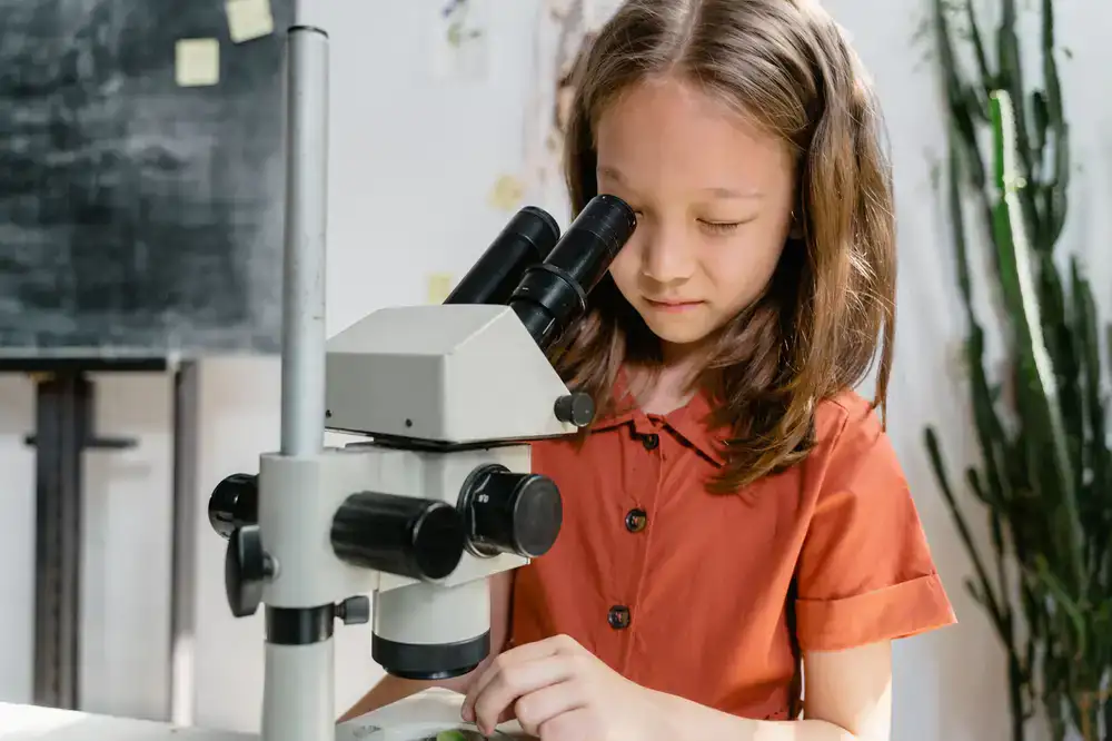 Child looking through a colorful microscope