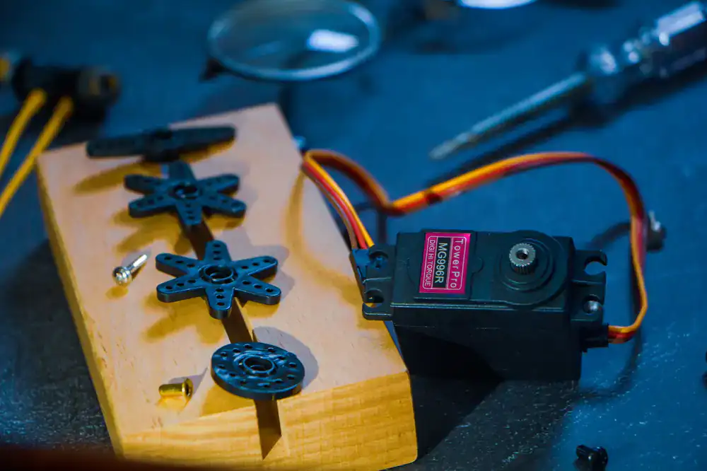 Close up of small motors and colorful gears being assembled by a young builder